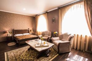 a living room with a bed and a table and chairs at Shah Palace Hotel in Bishkek