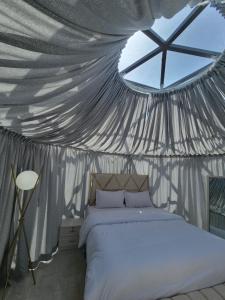 a bedroom with a bed in a tent at Blue Dome Chalet شاليه القبة الزرقاء in Al Raka