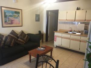 a living room with a couch and a table and a kitchen at Sunset Gardens Guesthouse in Charlotte Amalie