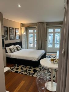 ein Schlafzimmer mit einem großen Bett und einem Tisch in der Unterkunft Oporto Chic & Cozy Cardosas in Porto