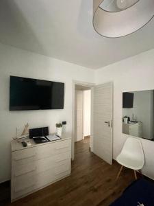 a room with a desk and a television on the wall at Enjoy Home in Acitrezza