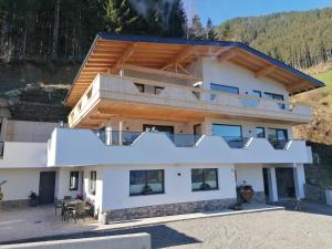 a white house with a wooden roof at Ferienwohnung Kirchler in Hippach