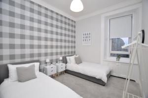 a bedroom with two beds and a window at The Warren Apartment in Greenock