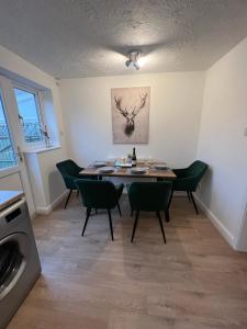 a dining room with a table and green chairs at Chase View - Dog Friendly - Close to Cannock Chase - Great Motorway Links - Perfect for contractors and leisure in Hednesford