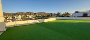 a balcony with green flooring on top of a building at Centro Carlos Paz 1 dormitorio in Villa Carlos Paz