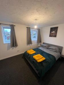 - une chambre avec un lit et 2 serviettes jaunes dans l'établissement Chase View - Dog Friendly - Close to Cannock Chase - Great Motorway Links - Perfect for contractors and leisure, à Hednesford