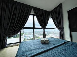 a bedroom with a blue bed with a large window at Cozy & Comfy Home Dsara Sentral Opposite MRT in Sungai Buluh