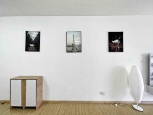 um quarto com uma parede branca com quatro fotografias em Cozy & Comfy Home Dsara Sentral Opposite MRT em Sungai Buluh