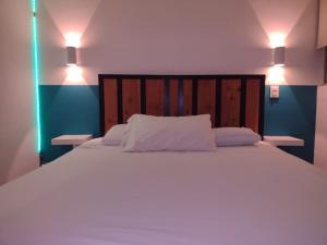 een slaapkamer met een groot bed met 2 verlichting bij Piso entero, cómodo y moderno in Mexico-Stad