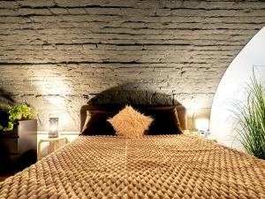ein Schlafzimmer mit einem großen Bett mit Ziegelwand in der Unterkunft Laura Boutique Apartment in Budapest