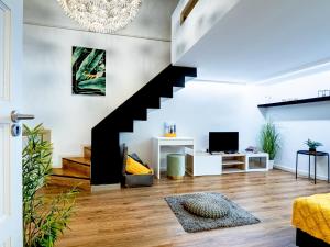 ein Wohnzimmer mit einer Treppe und einem TV in der Unterkunft Laura Boutique Apartment in Budapest