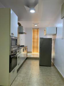 een keuken met een zwarte koelkast in de kamer bij Modern 2BDR APT - Wi-Fi, Kitchenette, Pool & 24hrs Security, Netflix in Ikeja
