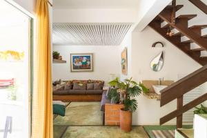 a living room with a couch and a staircase at Delba Costa Smeralda - Barra do Una in Barra do Una