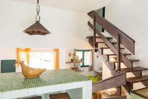 a room with a staircase and a table with a chair at Delba Costa Smeralda - Barra do Una in Barra do Una