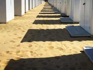 ein Strandhaus mit Fußabdrücken im Sand in der Unterkunft Maison Nausikaa in Ostende