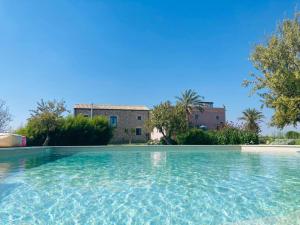 una grande piscina di fronte a una casa di Charming retreat in the sicilian countryside a Vittoria