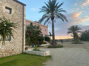 un edificio con palme di fronte ad esso di Charming retreat in the sicilian countryside a Vittoria
