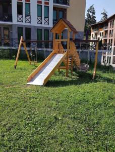 a wooden play set in the grass in a yard at Hotel Apollon in Bakuriani
