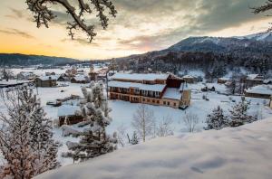 eine schneebedeckte Stadt mit einem Berg im Hintergrund in der Unterkunft Hotel Apollon in Bakuriani