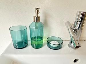 un lavabo con dos vasos, una botella y un grifo en FEEL - Casa di Luce, en Bérgamo