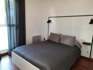 a bedroom with a bed with two pillows on it at A 200 m du centre historique, profitez d'un T2 spacieux avec balcon et parking privé in Quimper