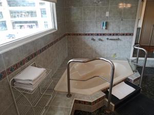 baño con bañera, lavabo y ventana en Hotel Sumaq Kay, en Cumbayá