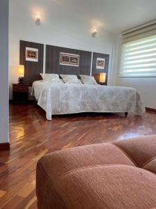two beds in a large room with wooden floors at Hotel Sumaq Kay in Cumbayá