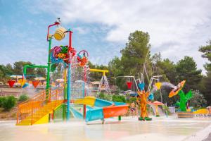 einen Wasserpark mit einem Wasserspielbereich mit Rutschen in der Unterkunft Le Pianacce Camping Village in Castagneto Carducci