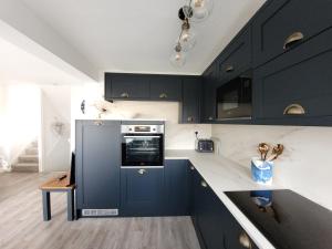 a kitchen with black cabinets and a black oven at Sea View 3 bedroom seaside property in Chichester