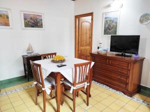 a dining room with a white table and a television at Casa Lupino in Orosei