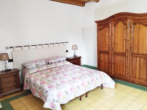 een slaapkamer met een bed en een houten kast bij Casa Lupino in Orosei