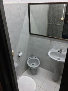 bagno con servizi igienici, lavandino e specchio di Hostel Parece Mentira a Colonia del Sacramento