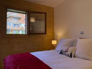 1 dormitorio con 1 cama blanca y ventana en La Perle des Alpes C10 Apart.4* #Yolo Alp Home, en Villard-sur-Doron