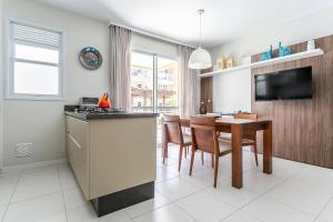 cocina y comedor con mesa y TV en 350m da Praia dos Ingleses #IA20, en Florianópolis