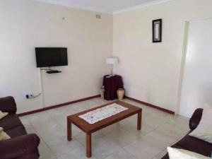 a living room with a couch and a coffee table at 2 bed guesthouse in Mabelreign - 2012 in Harare