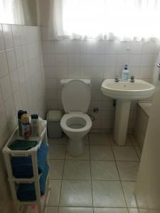 a bathroom with a toilet and a sink at 2 bed guesthouse in Mabelreign - 2012 in Harare