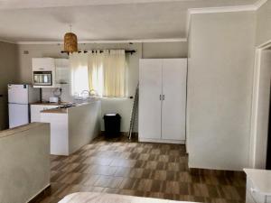 a kitchen with white cabinets and a kitchen with a floor at 1 bed apartment in Mount Pleasant Heights - 2013 in Kingsmead