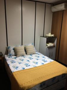 a bedroom with a large bed with blue flowers on it at Hostel Parece Mentira in Colonia del Sacramento