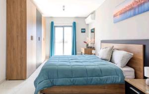 a bedroom with a blue bed and a window at Stylish 3Bed Penthouse close to the Blue Grotto in Żurrieq