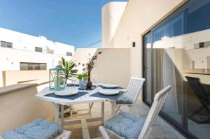 a table and chairs on the balcony of a house at Stylish 3Bed Penthouse close to the Blue Grotto in Żurrieq