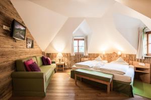 um quarto no sótão com 2 camas e um sofá em Grossarler Hof Superior em Grossarl