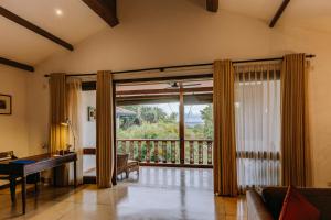 a living room with a piano and a large window at Aditya Resort in Hikkaduwa