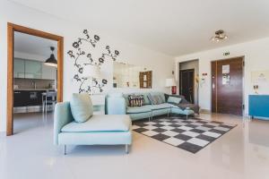 a living room with a blue couch and a chair at Best Houses 03 - Deluxe Two Bedrooms and Pool - Design Apartment in Ferrel