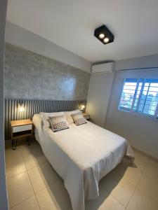 Un dormitorio con una gran cama blanca y una ventana en Salta 5 - Bon Repos en San Miguel de Tucumán