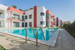 a swimming pool in front of a building at Best Houses 03 - Deluxe Two Bedrooms and Pool - Design Apartment in Ferrel