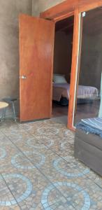 a room with a door and a carpeted floor with a bedroom at Hospedaje Rural Casa de Felix in San Pedro de Atacama