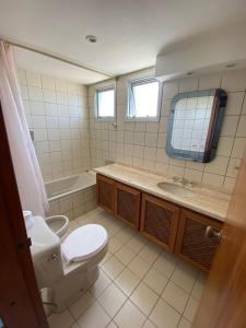 a bathroom with a toilet and a sink and a tub at Cap Breton - PentHouse in Punta del Este