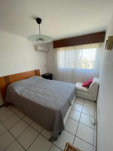 1 dormitorio con 1 cama y 1 sofá en Cap Breton - PentHouse, en Punta del Este