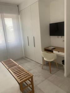 Habitación con escritorio, silla y TV. en fuORIOrbita en Orio al Serio