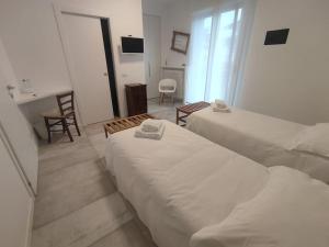 a hotel room with two beds and a desk at fuORIOrbita in Orio al Serio